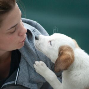 Woman Wearing Gray Jacket Beside White Puppy