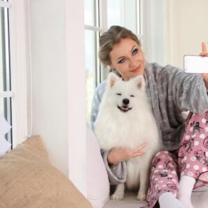 Woman Taking a Photo of Herself With White Dog