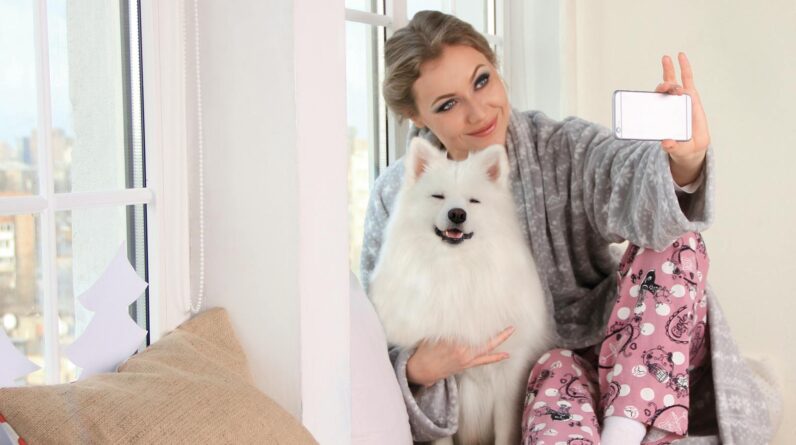 Woman Taking a Photo of Herself With White Dog