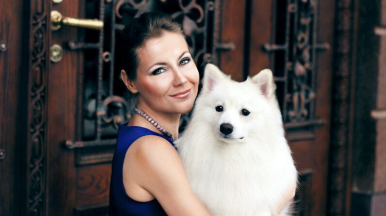 Woman Carrying Adult White Indian Spitz
