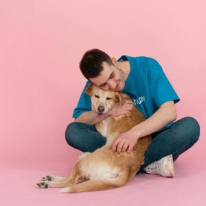 Man Sitting on the Floor while Hugging a Dog