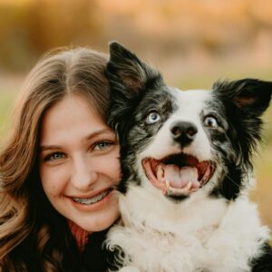 a woman is hugging a dog in a field