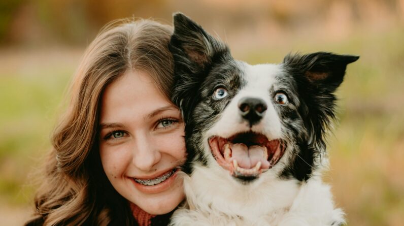 a woman is hugging a dog in a field
