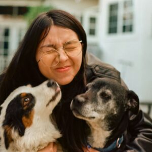 a woman holding two dogs in her arms