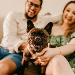 a man and woman sitting on a couch with a dog