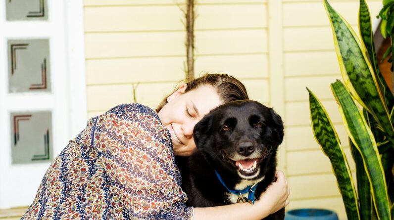 woman hugging black dog